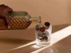 How Investing in Whiskey Outperformed the S&P500 A Person Pouring Liquor in the Clear Glass with Coins